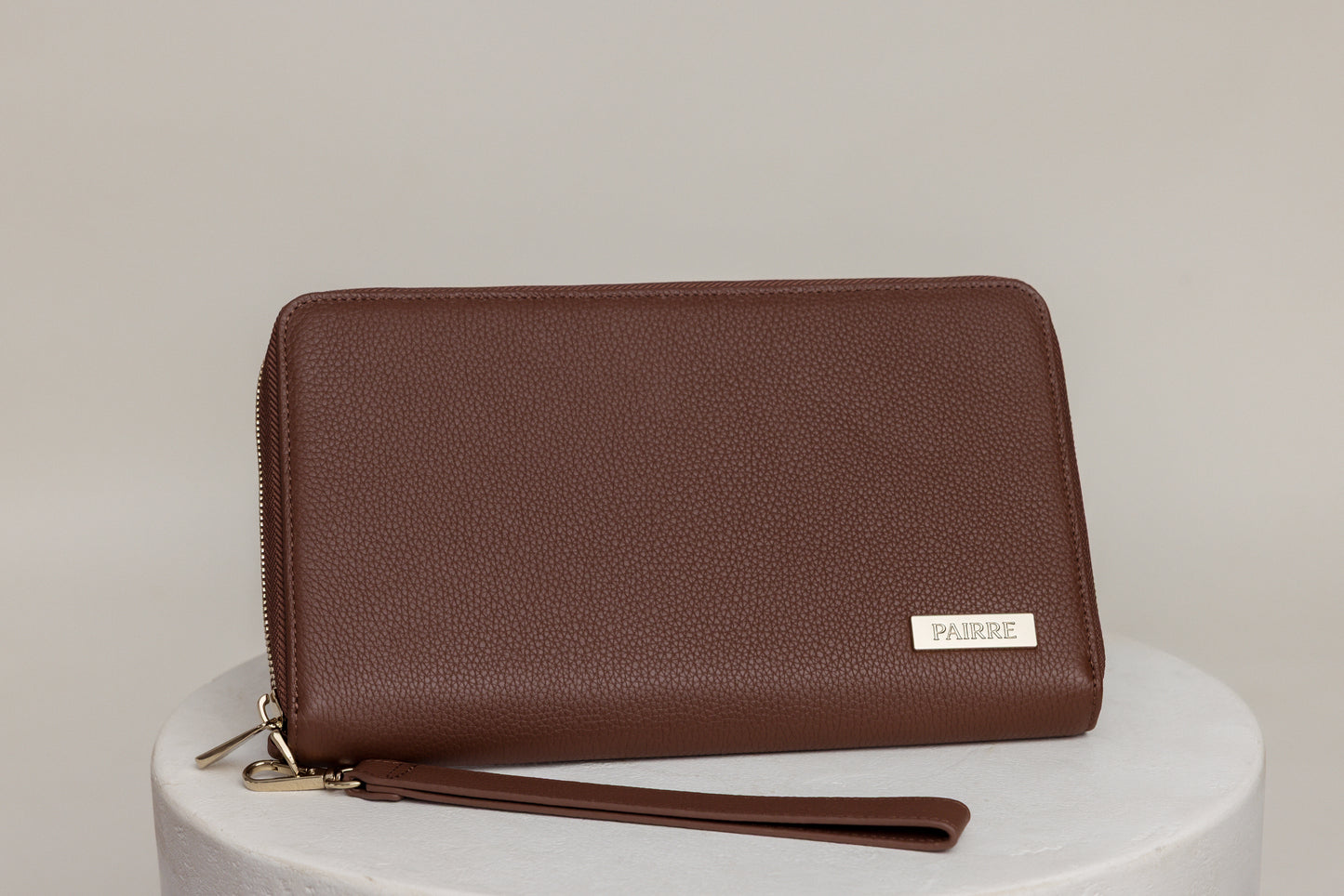 Pairre 4P passport wallet in brown full-grain leather — closed exterior showing PVD gold hardware