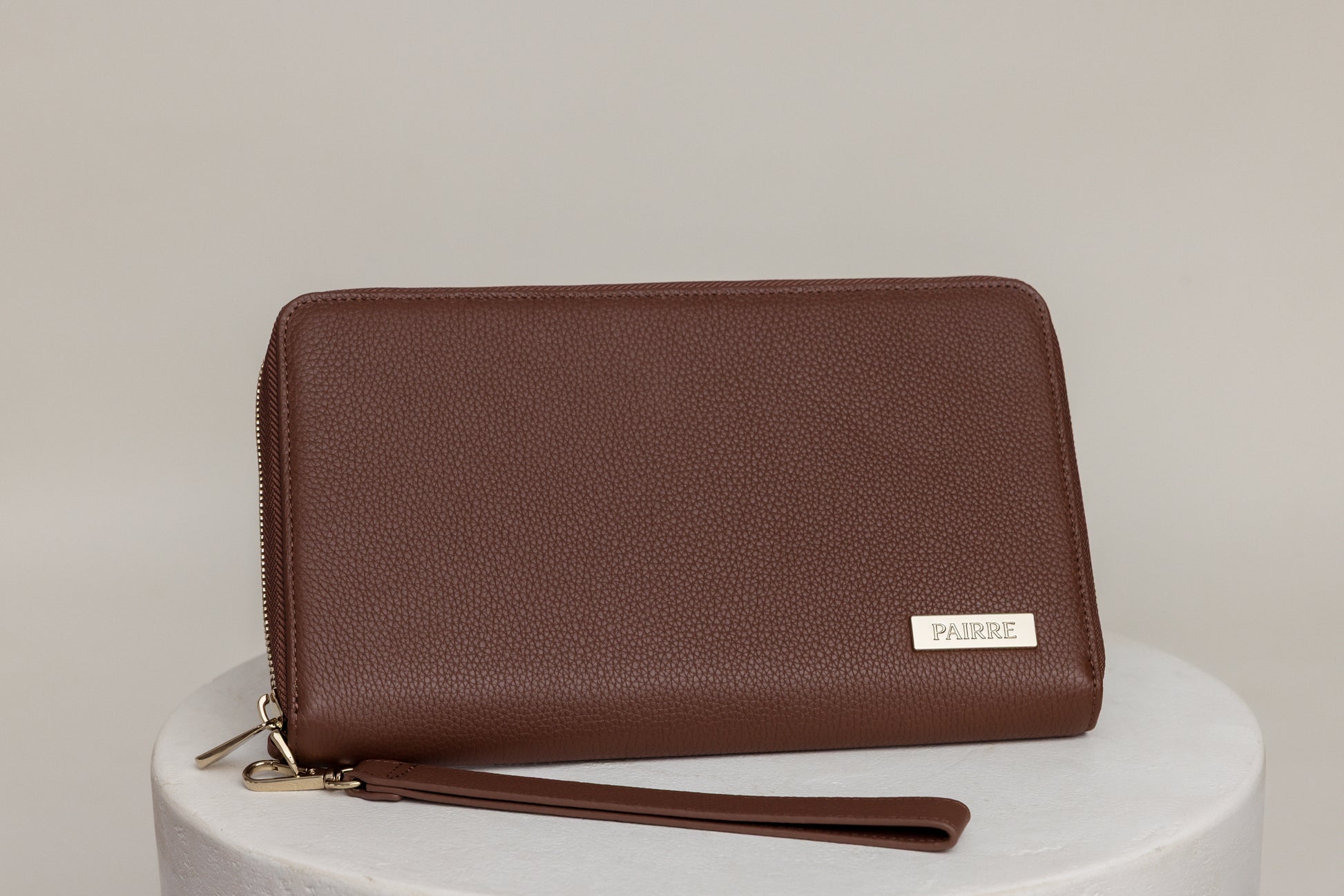 Pairre 4P passport wallet in brown full-grain leather — closed exterior showing PVD gold hardware