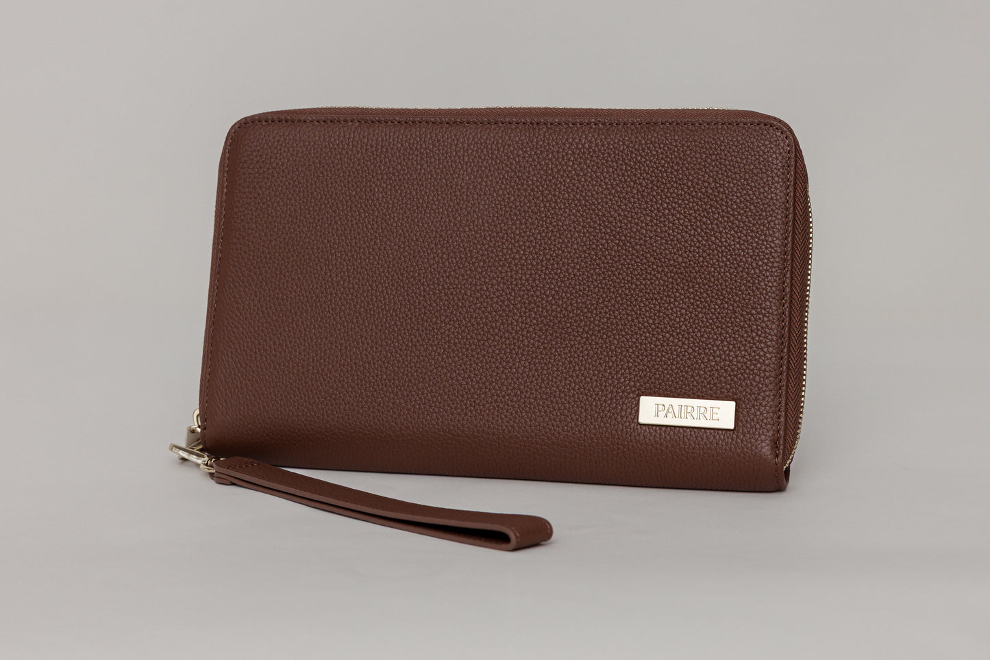 Pairre 4P passport wallet in brown full-grain leather — closed exterior showing PVD gold hardware