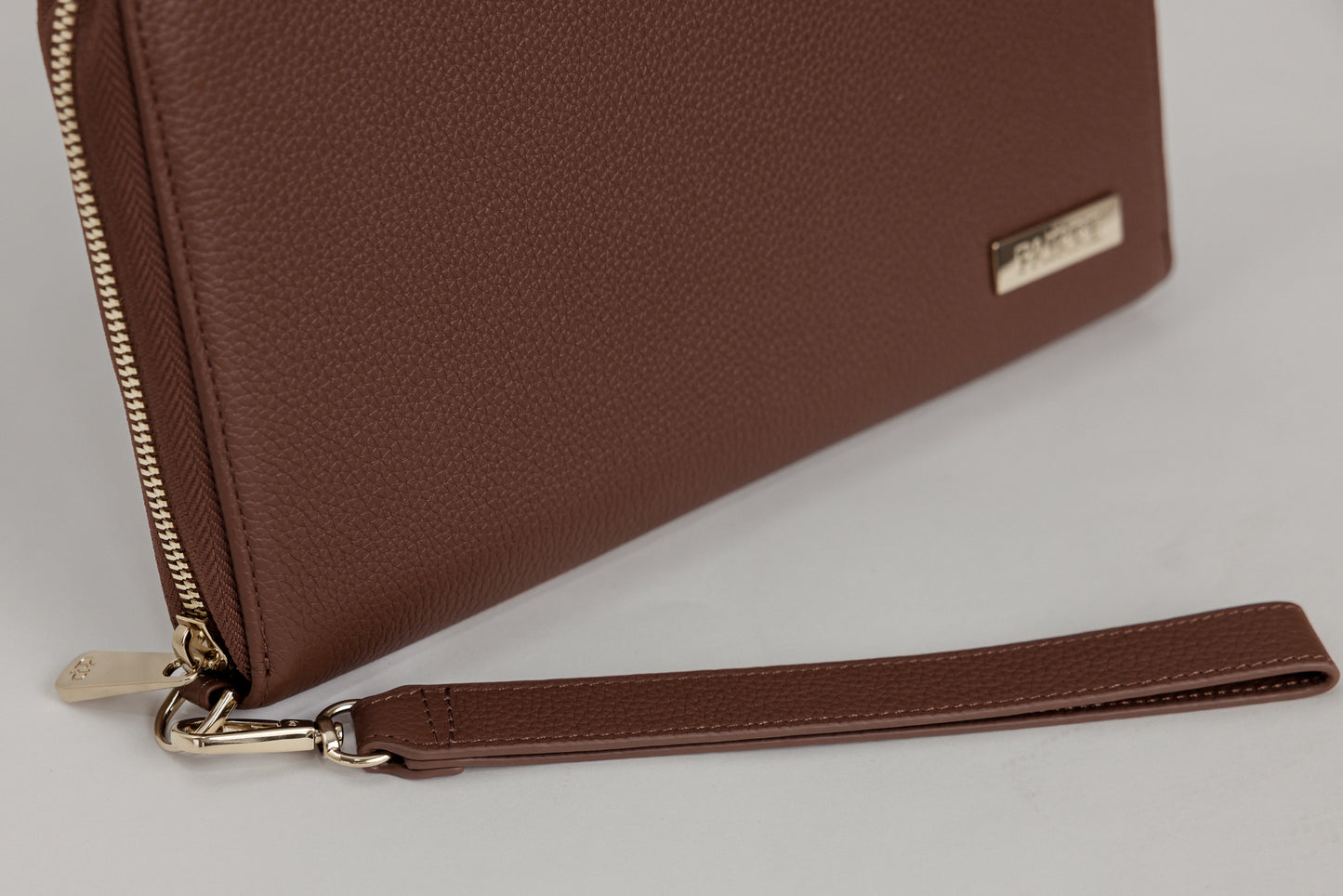 Pairre 8P brown leather passport wallet — close up of PVD gold Pairre hardware plate - pvd clasp - pvd zip puller