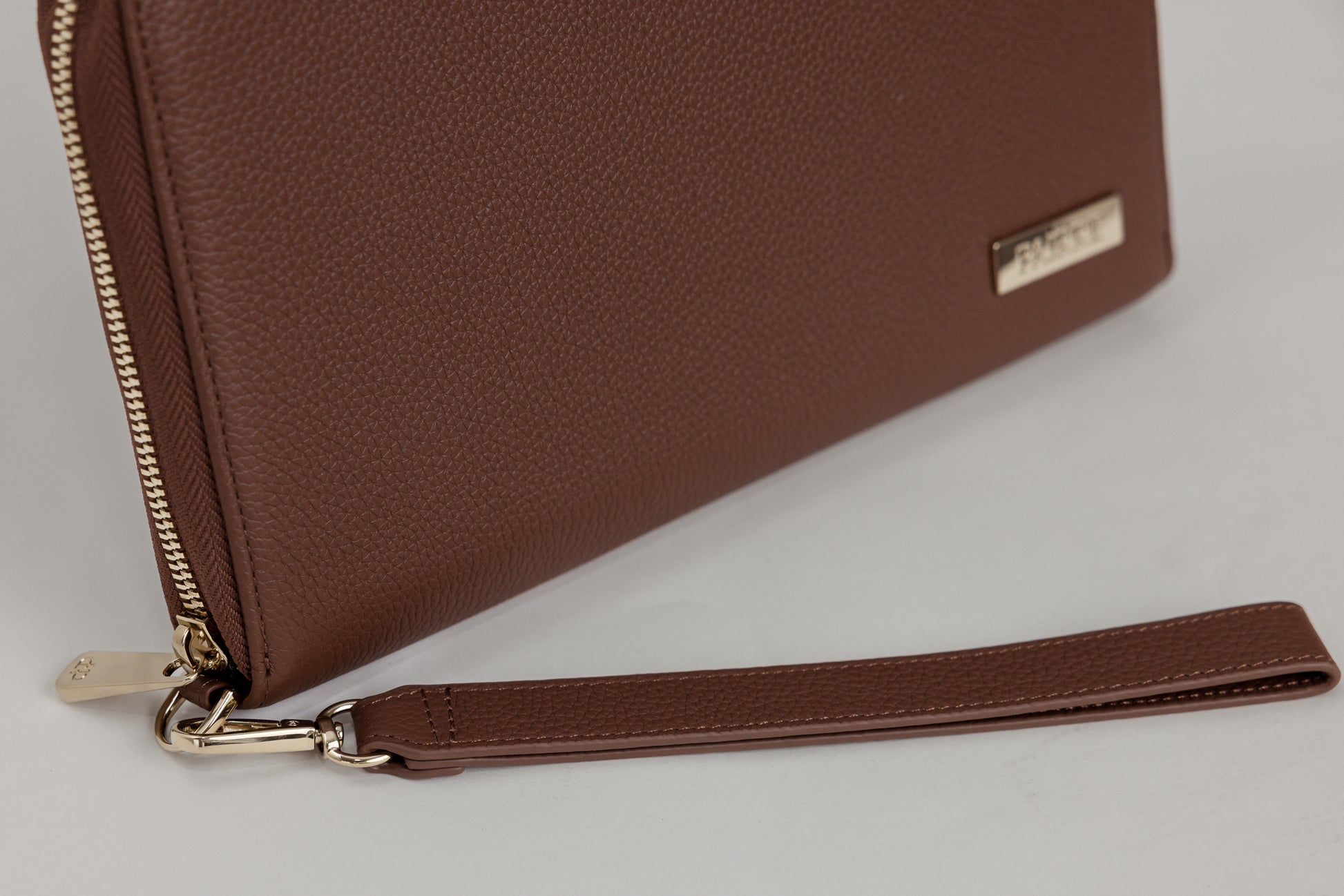 Pairre 8P brown leather passport wallet — close up of PVD gold Pairre hardware plate - pvd clasp - pvd zip puller