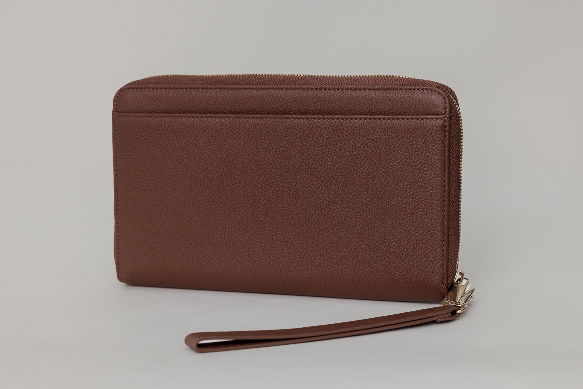 Pairre 4P passport wallet in brown full-grain leather — closed exterior showing PVD gold hardware - rear slip pocket