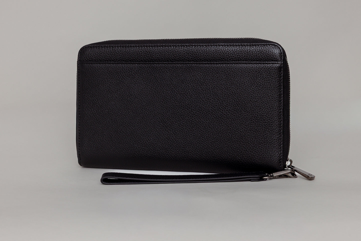 Pairre 4P passport wallet in black full-grain leather — closed exterior showing PVD gold hardware And exterior slip pocket