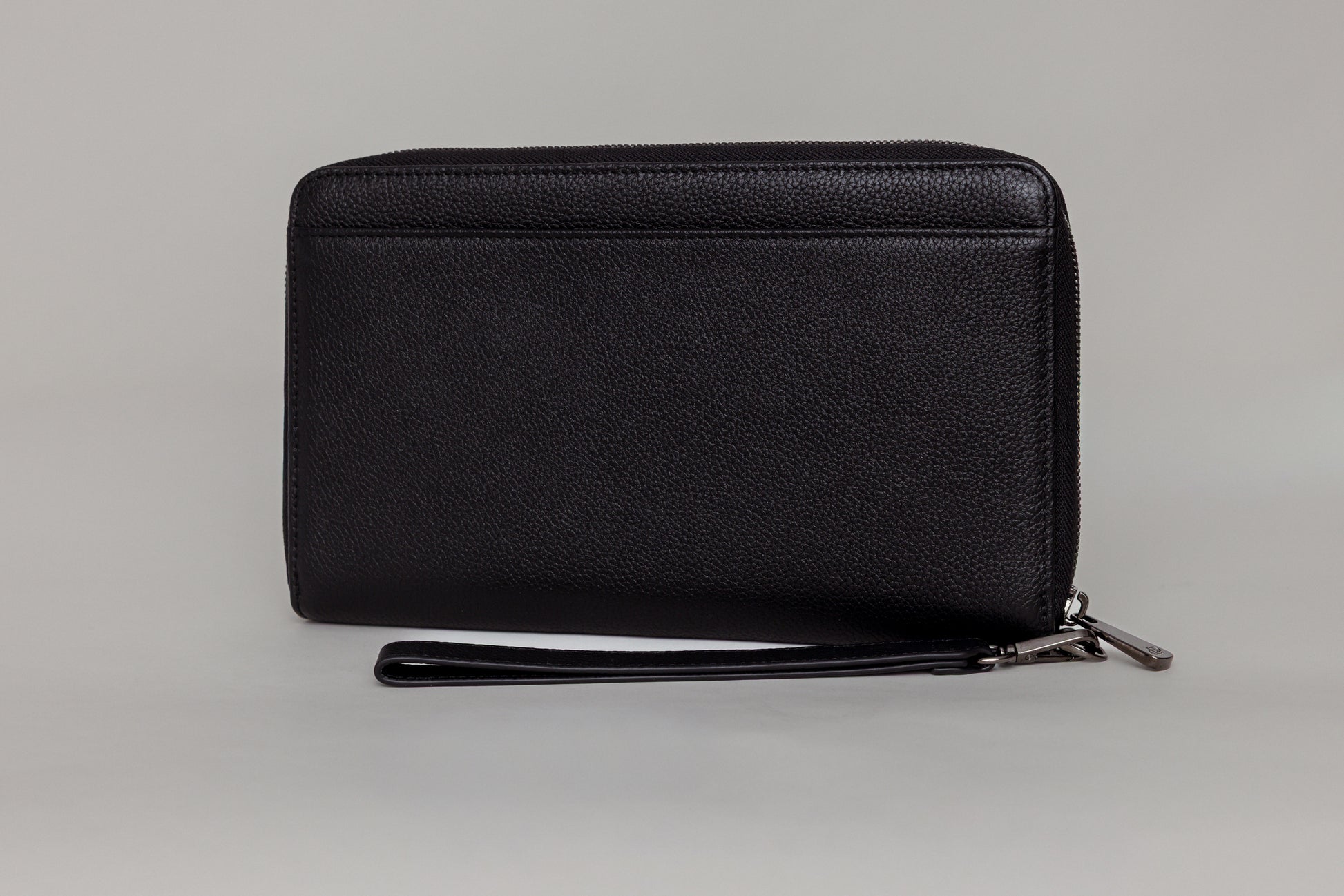 Pairre 4P passport wallet in black full-grain leather — closed exterior showing PVD gold hardware And exterior slip pocket