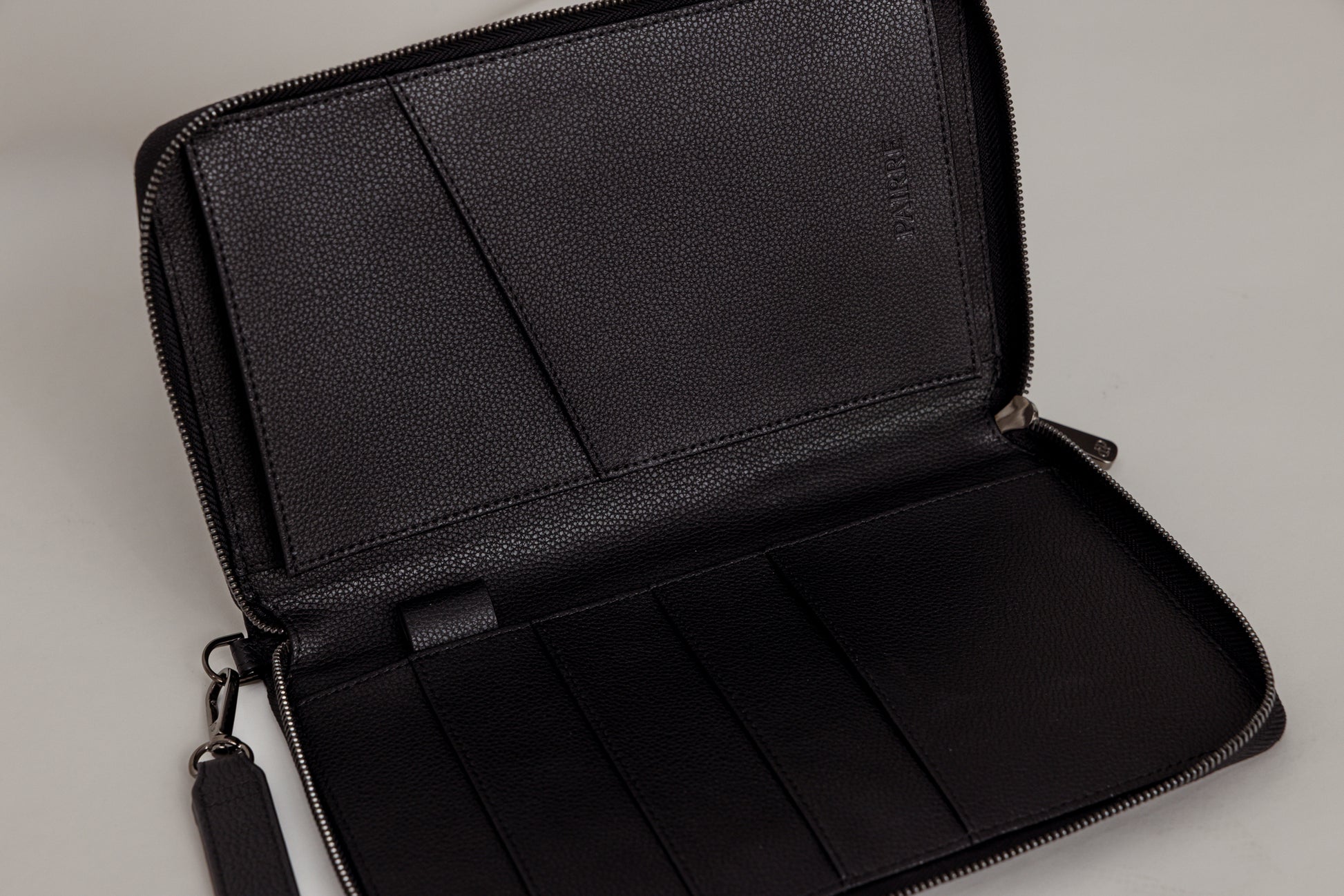 Pairre 4P passport wallet in black leather — open interior showing four passport slots and boarding pass pocket