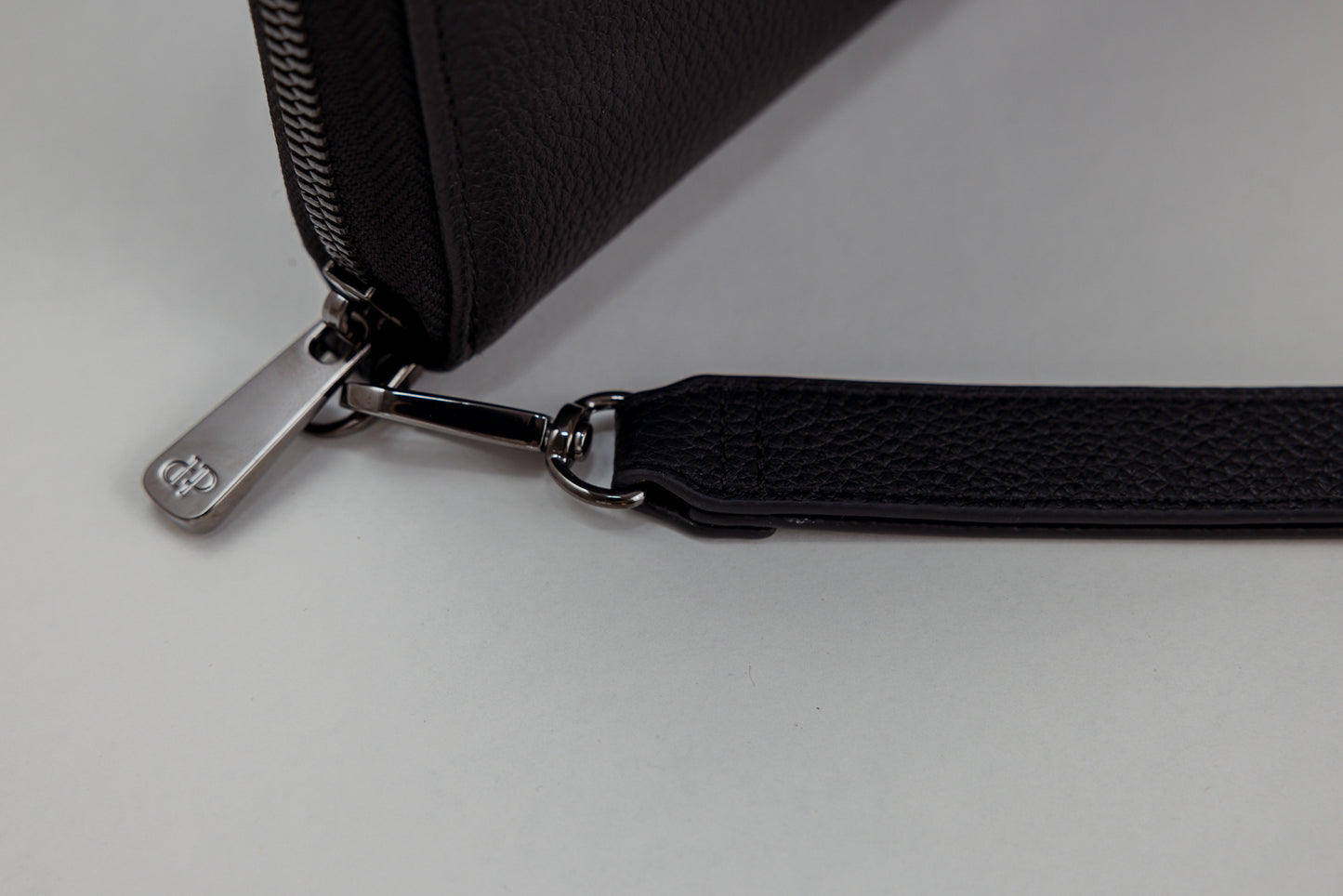 Pairre 4P black leather passport wallet — close up of PVD gold Pairre hardware plate