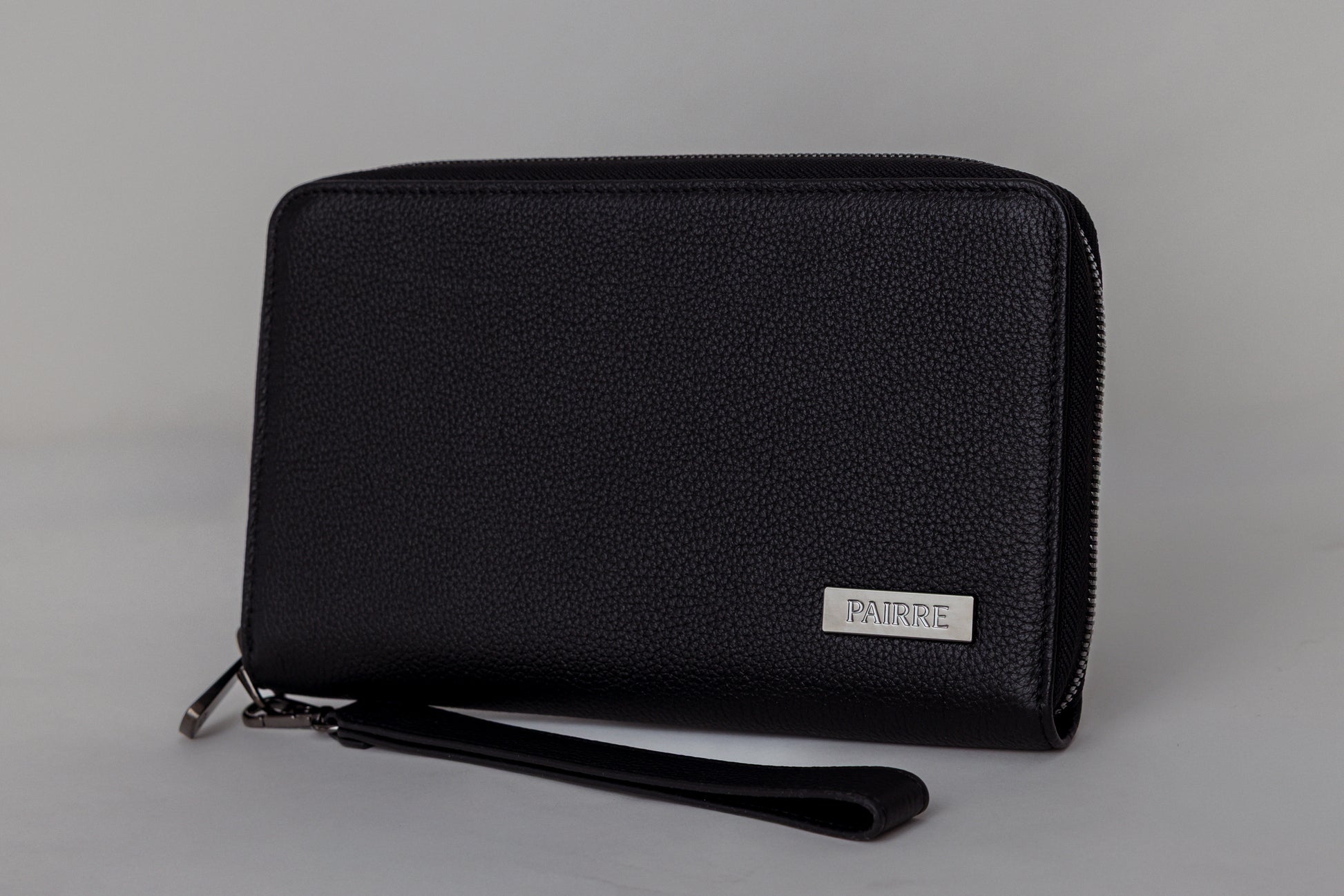 Pairre 2P black leather passport wallet - close up of PVD gold Pairre hardware plate