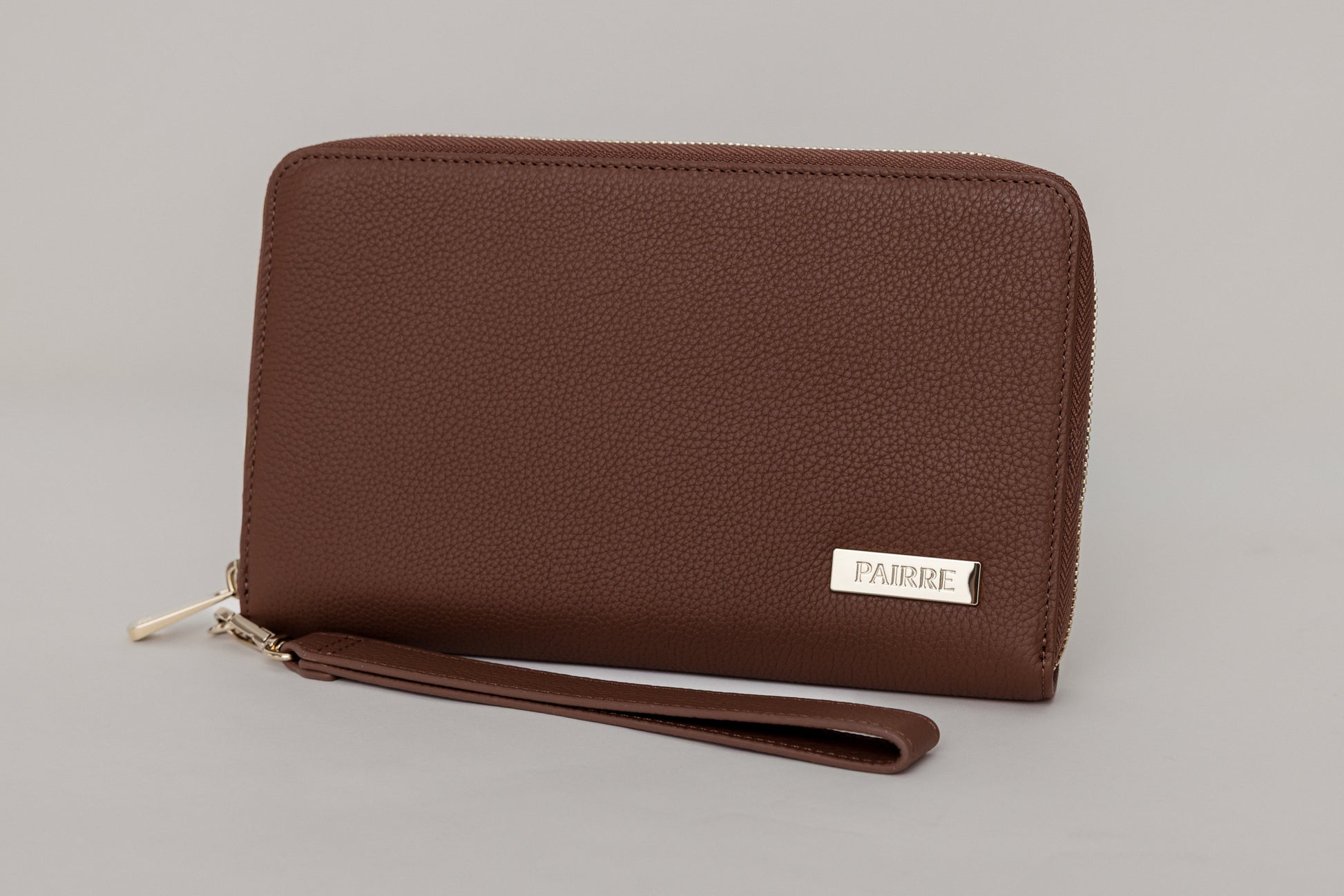 Pairre 2P brown/espresso leather passport wallet - close up of PVD gold Pairre hardware plate
