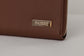Pairre 2P brown/espresso leather passport wallet — close up of PVD gold Pairre hardware plate