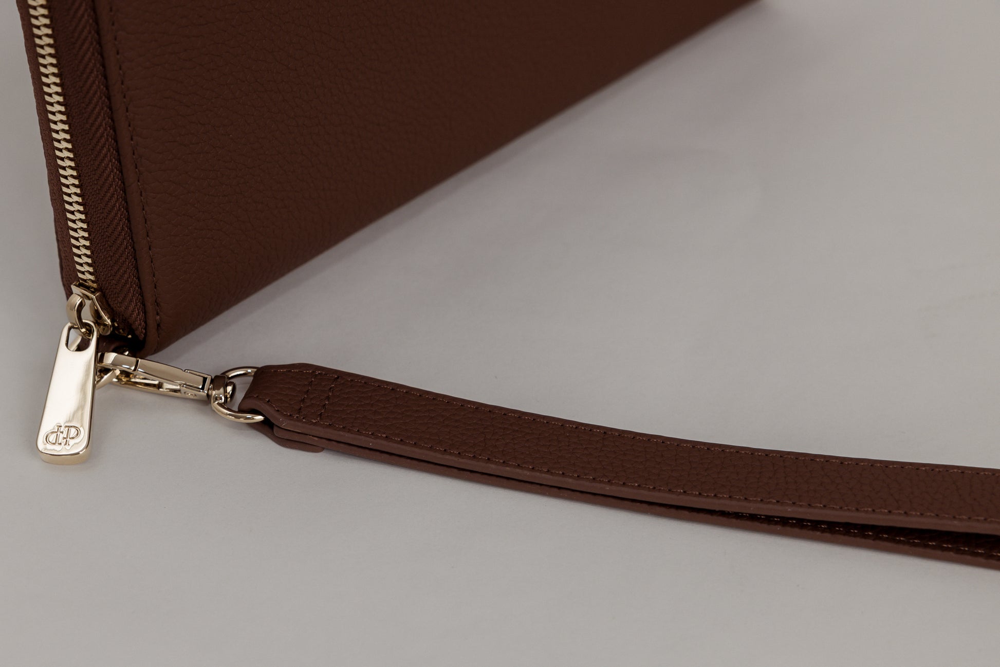Pairre 2P passport wallet in brown/espresso full-grain leather — closed exterior showing close up PVD gold hardware