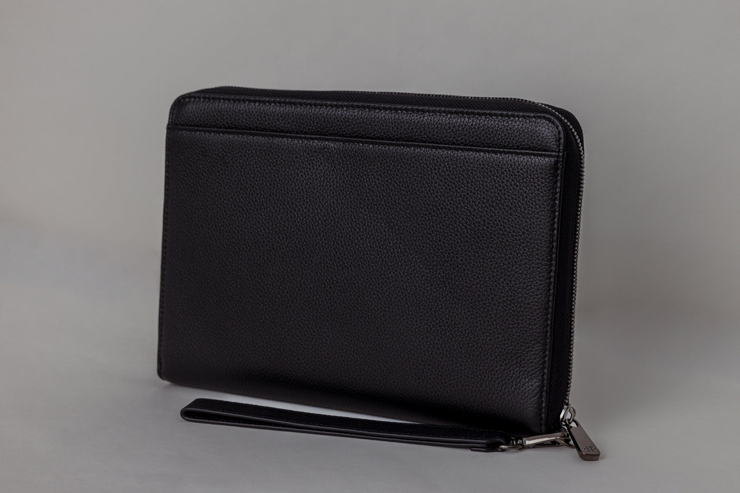 Pairre 8P passport wallet in black full-grain leather — closed exterior showing PVD gold hardware - rear slip pocket