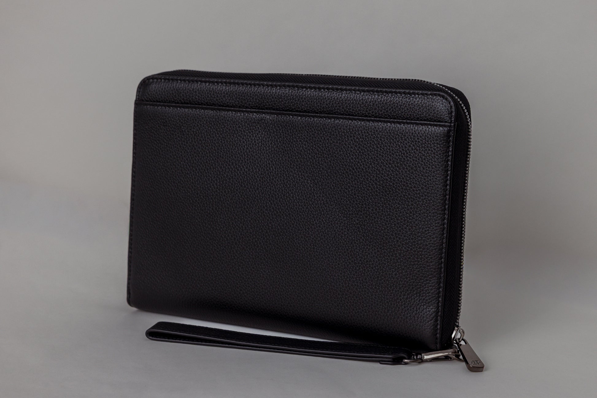 Pairre 8P passport wallet in black full-grain leather — closed exterior showing PVD gold hardware - rear slip pocket