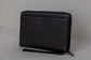 Pairre 8P passport wallet in black full-grain leather — closed exterior showing PVD gold hardware - rear slip pocket