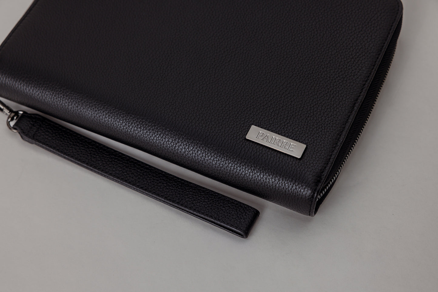 Pairre 8P black leather passport wallet — close up of PVD gold Pairre hardware plate