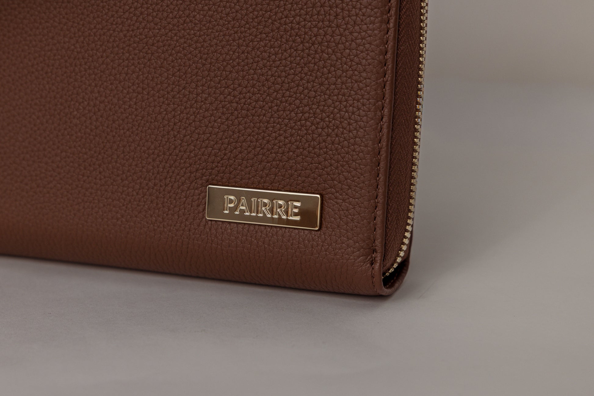 Pairre 8P brown leather passport wallet — close up of PVD gold Pairre hardware plate