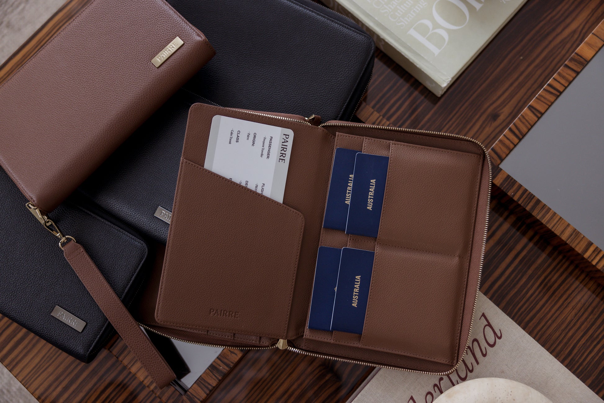Pairre 8P brown/espresso leather passport wallet — lifestyle shot - Pairre 8P brown passport wallet flat lay with multiple passports and travel documents